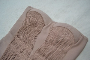 Detailed view of beige bandage corset top featuring dense fringe and strapless design