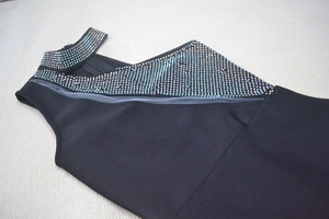 Detail of black bandage dress showing colorful rhinestone neck and mesh insert