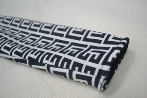 Macro detail of high-quality black and white geometric jacquard fabric with fine stitching
