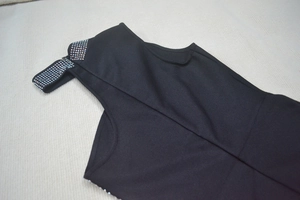 Detailed close-up of high neck collar with colorful rhinestones on black bandage dress