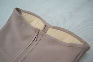 Close-up of nude bandage top featuring front zipper and internal anti-slip silicone strips