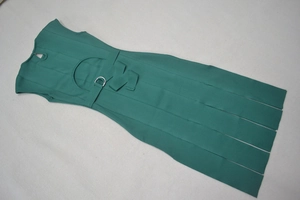 Détail de la robe vert foncé montrant la boucle à la taille et les découpes sexy