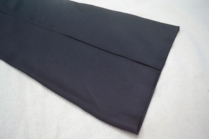 Detail view of a black bandage dress featuring a side slit and premium stitching