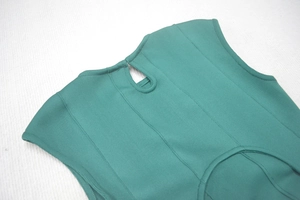 Détail d'une robe côtelée vert foncé avec décolleté goutte d'eau et coutures apparentes