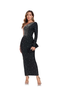 Détail de la robe noire asymétrique avec des perles blanches brodées pour une soirée chic