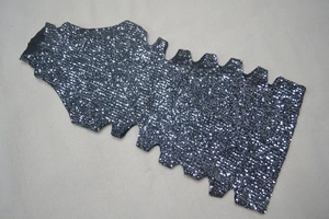 Close-up of sparkling black sequin fabric with unique side cutout detail and mock neck