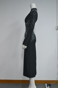 Close-up of sparkling silver rhinestones and beadwork on a slim fit black bandage dress