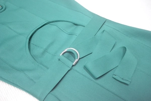 Détail de la texture d'une robe bandage turquoise avec boucle en D argentée et côtes