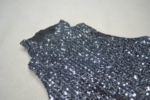 Macro shot of sequin sleeveless dress detailing black and silver paillettes and lining
