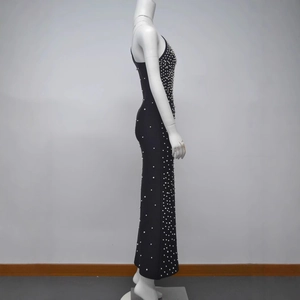 Détail d'une robe bandage noire sans manches avec des ornements de perles blanches élégantes