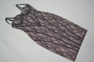 Vue détaillée d'une robe bandage en dentelle noire avec motifs floraux et doublure nude