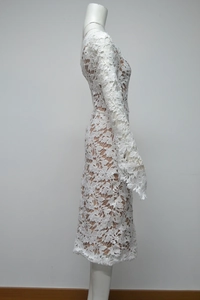 Detailed view of white lace maxi dress featuring intricate floral patterns and flare sleeves