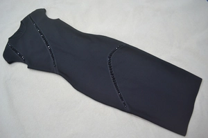 Close-up of black sleeveless bandage dress showing diagonal rhinestone and bead details