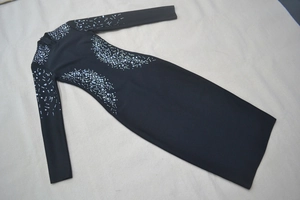 Detailed view of silver rhinestones and sequins on a black long-sleeve bandage dress