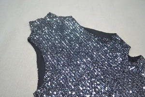 Flat lay of a black sequined sleeveless dress featuring side cutouts and a high neck