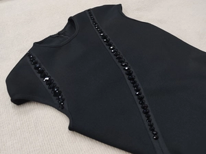 Close-up of black bandage dress showing rhinestone bead details and invisible back zipper