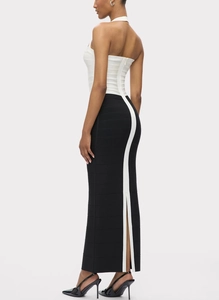 Rear view of sleek black and white bandage dress showing the elegant back slit and halter design