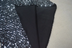 Detail shot of shimmering silver and black sequins with smooth inner lining fabric