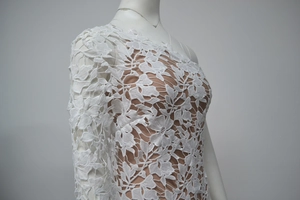 Detailed close-up of intricate white floral lace pattern with breathable mesh lining