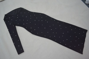 Détail de la robe bandage noire avec perles élégantes et strass argentés brillants