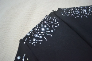Close-up of black bandage dress featuring intricate silver rhinestones and invisible zipper