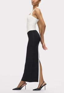 Detail of elegant black and white bandage dress featuring a side high slit and textured fabric