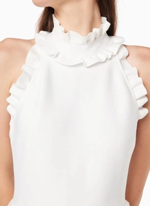 Detail of high collar with ruffled edges and sleeveless design on a white dress