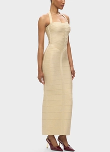 Détail d'une robe bandage dorée avec encolure licou et texture horizontale ajustée chic