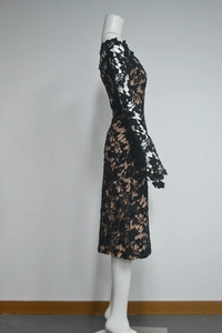 Close-up of elegant black floral lace fabric with nude lining on long sleeve dress