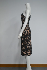 Detailed close-up of intricate black floral lace and beige lining on a formal dress