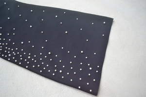 Gros plan sur le tissu noir avec perles blanches et broderies perlées artisanales de luxe