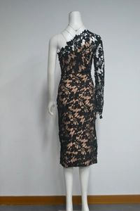 Detail of elegant black lace one-shoulder dress with floral pattern over nude lining