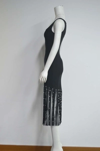 Détail de la robe bandage noire avec des franges élégantes en paillettes argentées sur l'ourlet