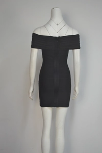 Détail de la fermeture éclair et du tissu texturé d'une robe bandage noire à épaules nues