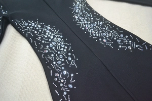 Detailed macro view of sparkling silver rhinestones on luxury black bandage dress fabric