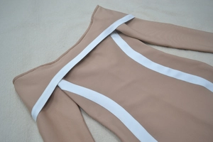 Détail de maille côtelée camel avec rayures blanches sur robe à épaules dénudées