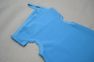 Vue détaillée d'une robe bandage bleue avec texture en maille côtelée et design asymétrique