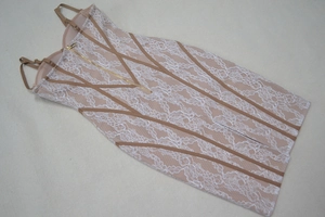 Détail de robe bandage nude avec dentelle florale blanche et fermeture éclair dorée au dos