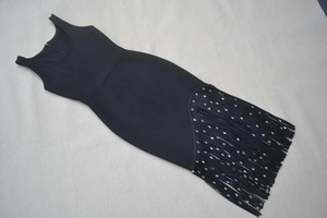 Détail d'une robe bandage noire avec ourlet à franges pailletées en coupe ajustée