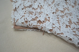 Close-up of white floral lace evening dress with seamless invisible side zipper detail
