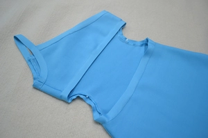 Détail du tissu bleu ciel de la robe bandage montrant la texture et la couture précise