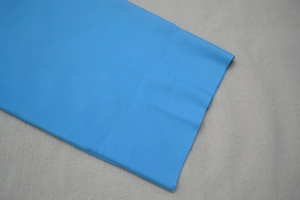 Gros plan sur le tissu bleu vif de la robe bandage montrant la texture premium