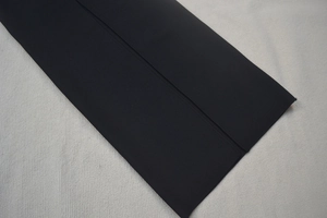 Dettaglio in primo piano di tessuto nero con cuciture precise e rifiniture di qualità