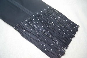 Détail de la robe bandage noire avec des franges élégantes ornées de strass argentés
