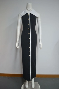 Détail d'une robe noire élégante avec bande contrastée blanche et dix boutons en perles