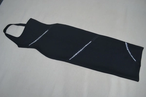 Détail de la robe licou noire ornée de bandes décoratives en strass étincelants