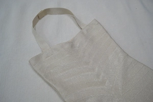 Détail de la robe bandage dorée montrant la texture croisée complexe du tissu