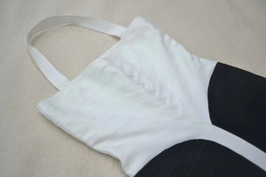 Detail of black and white bandage dress featuring textured fabric and halter neckline