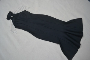 Detailed view of elegant sleeveless bandage dress with layered pearl shoulder chains