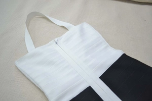Detail of contrast bandage dress featuring a halter neck and front zipper closure